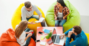 Top view of 4 young people sitting on bean bags having a meeting